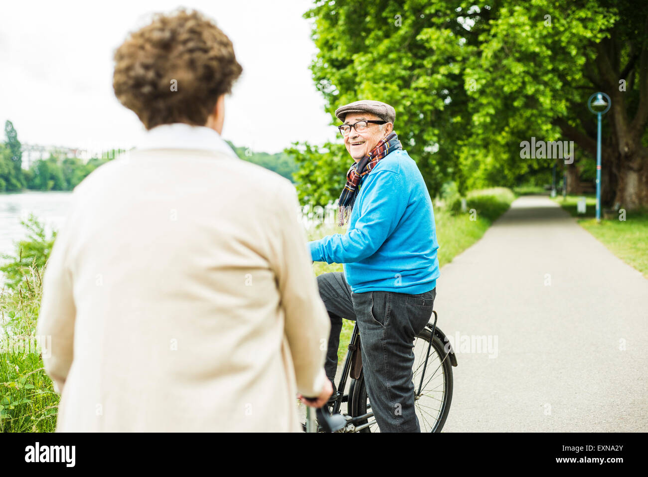 Glücklicher senior Mann mit Fahrrad von Angesicht zu Angesicht seiner Frau Stockfoto