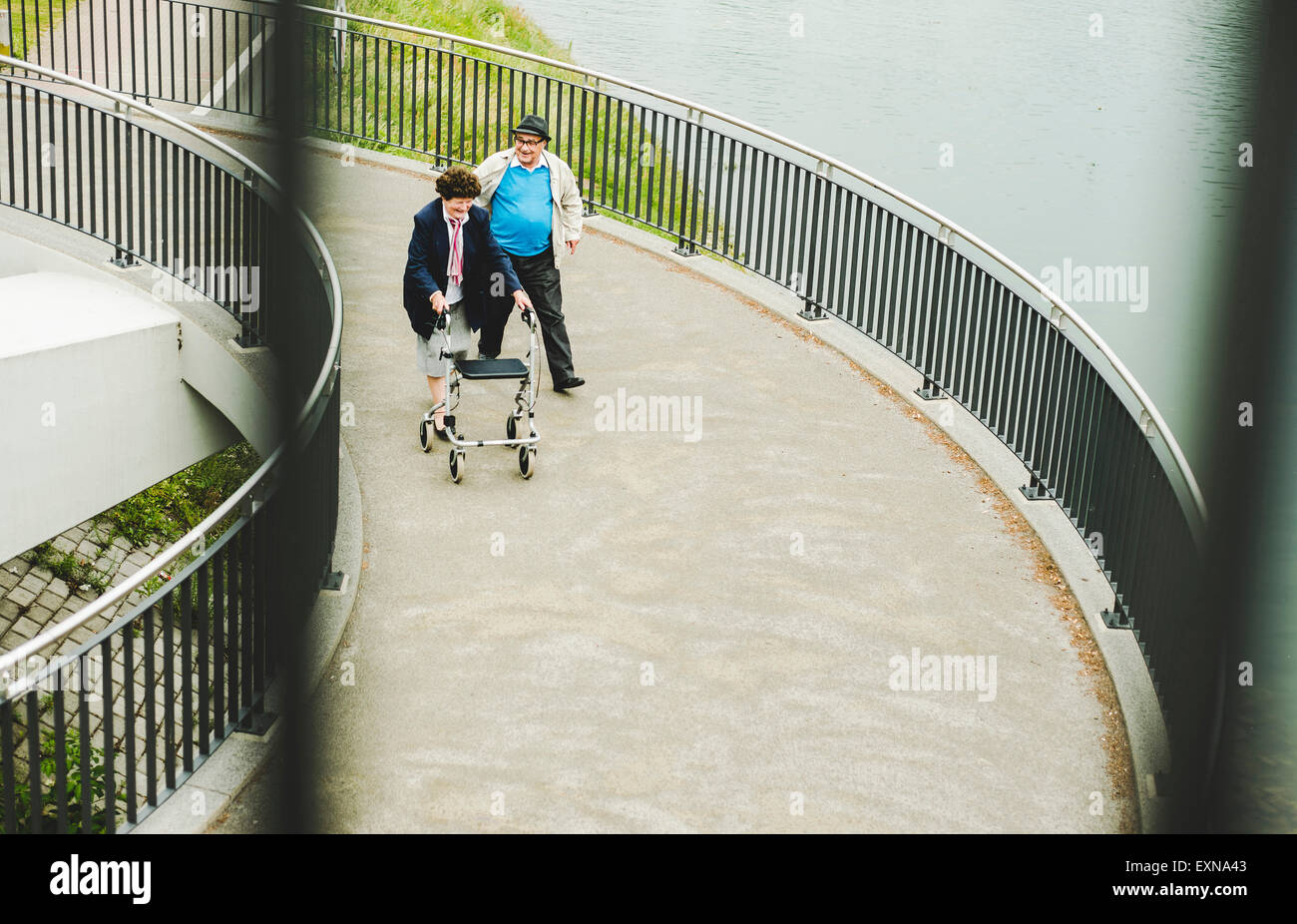 Älteres Paar mit Gehstock und Rädern Walker auf einer Brücke Stockfoto