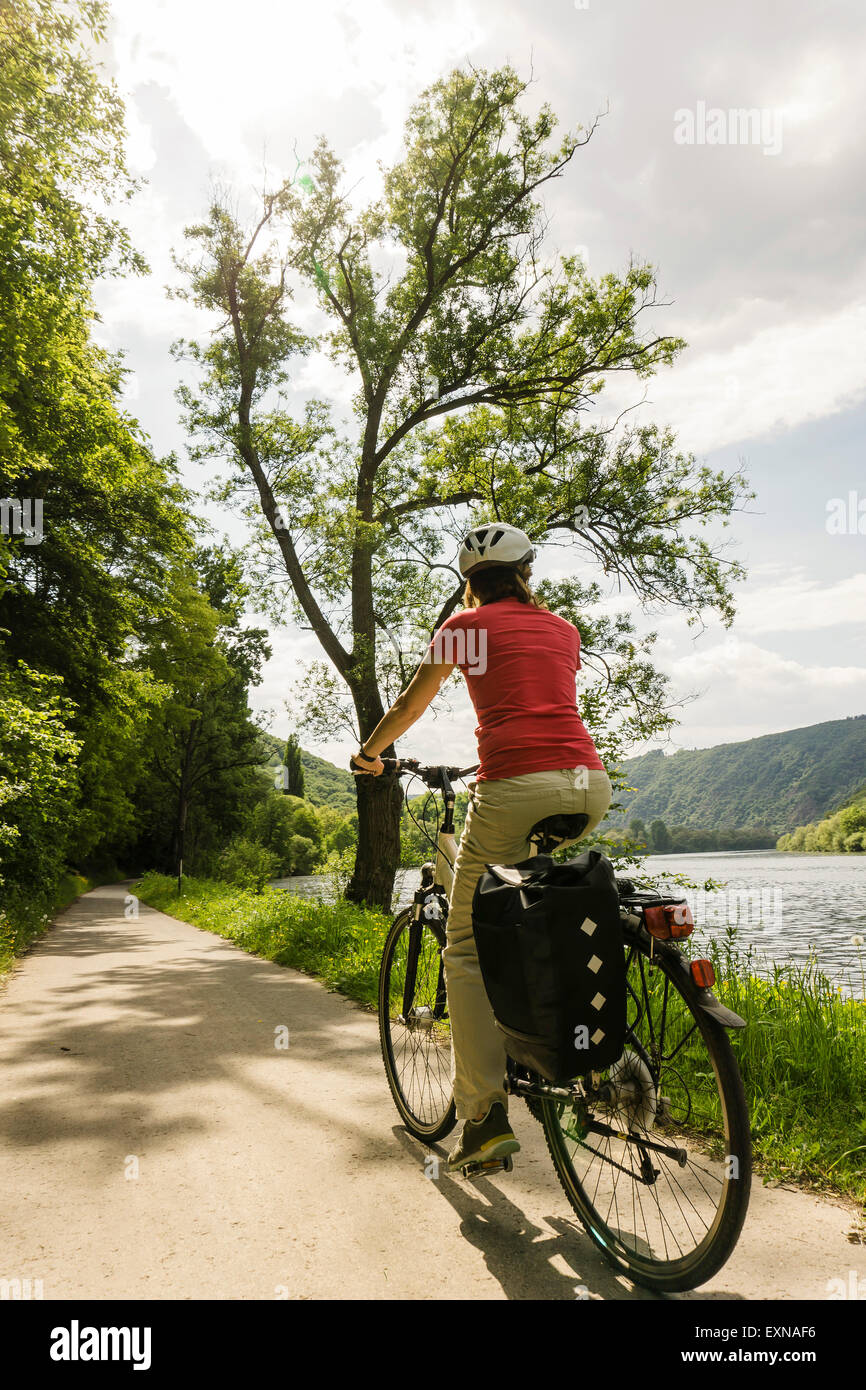 Deutschland, Cochem, Frau Reiten Fahrrad entlang der Ufer der Mosel Stockfoto