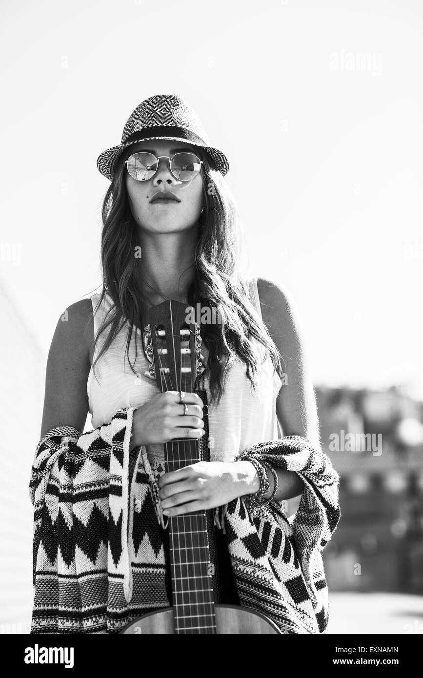 Junge Frau trägt Boho Stil halten Gitarre Stockfoto