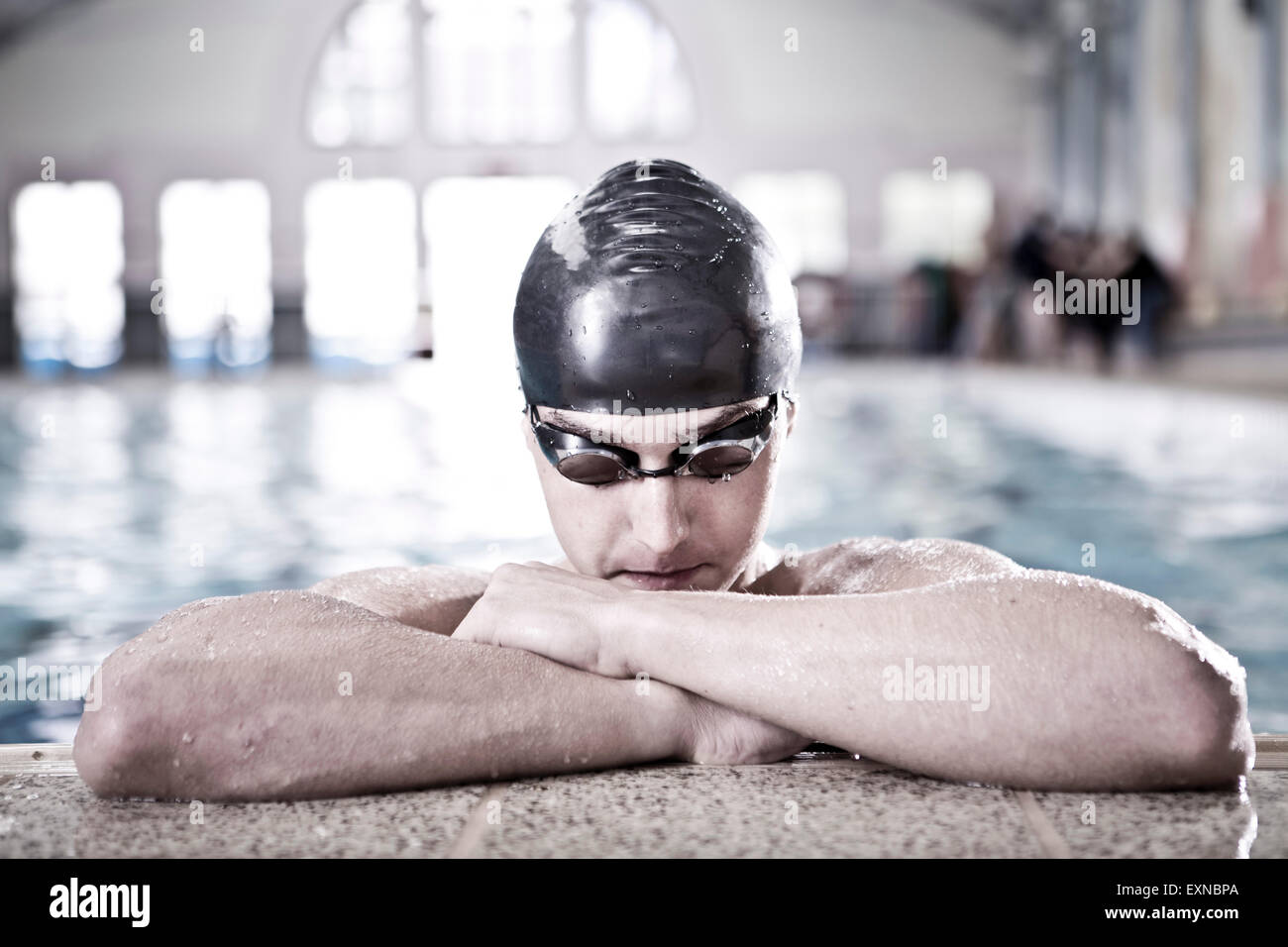 Schwimmer im Hallenbad am Beckenrand Stockfoto