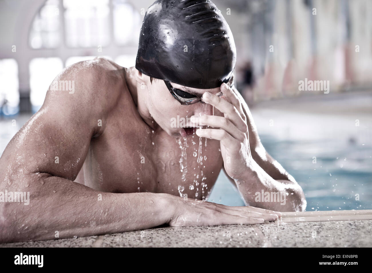 Schwimmer im Hallenbad am Beckenrand Stockfoto