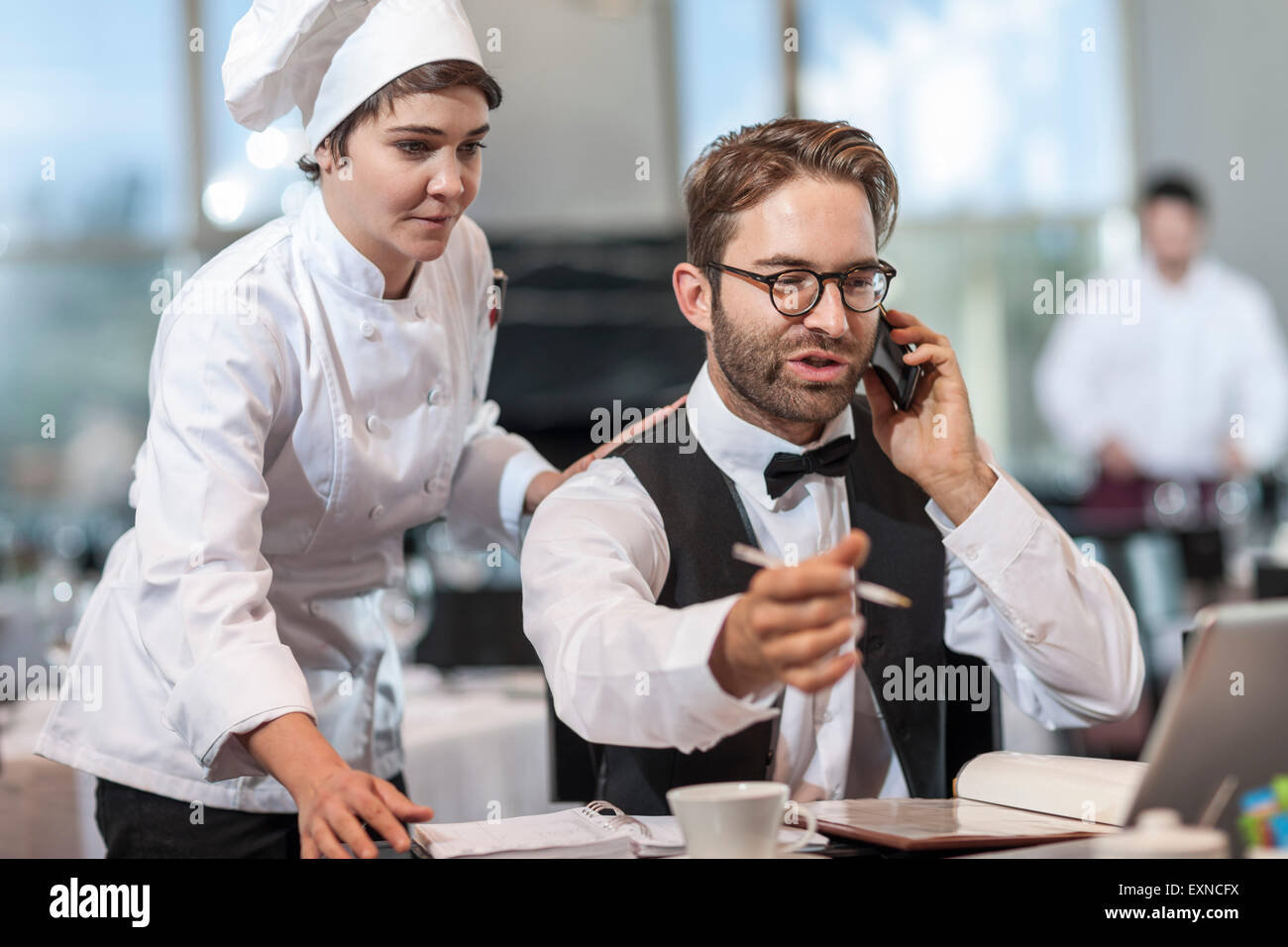 Restaurant-Chef und Manager diskutieren Reservierungen Stockfoto