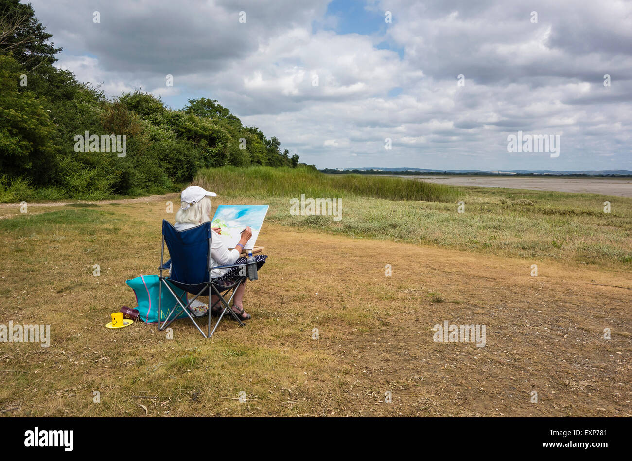 Artist sitzen Malerei die Landschaft in Pagham Harbour, West Sussex, England, Großbritannien Stockfoto