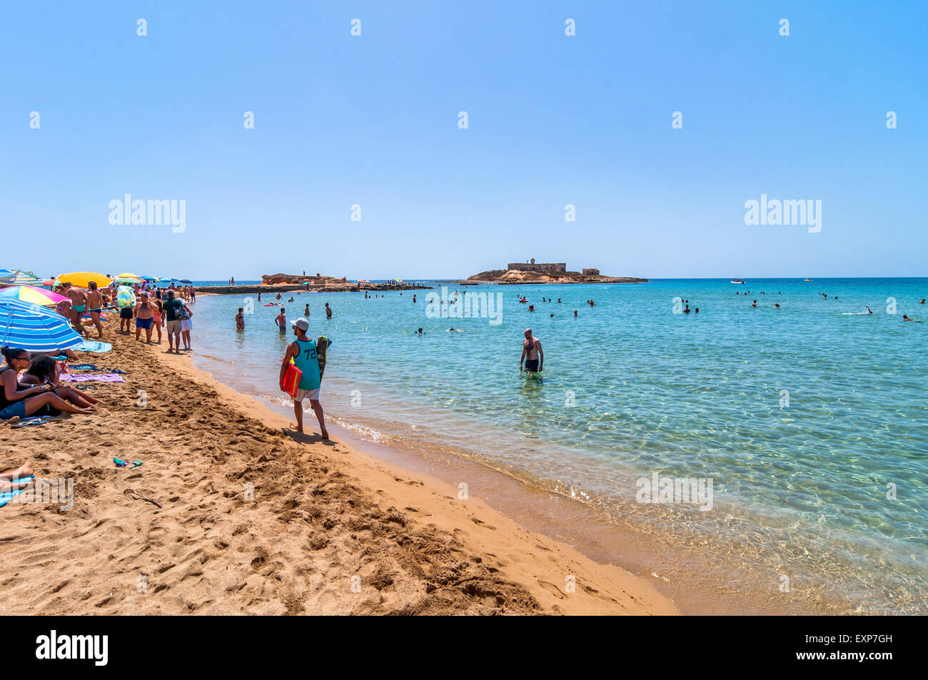 PORTOPALO, Italien - 19. August 2014: Touristen und Einheimische genießen blaues Meer auf Isola Delle Correnti Strand in Portopalo, Sizilien Stockfoto