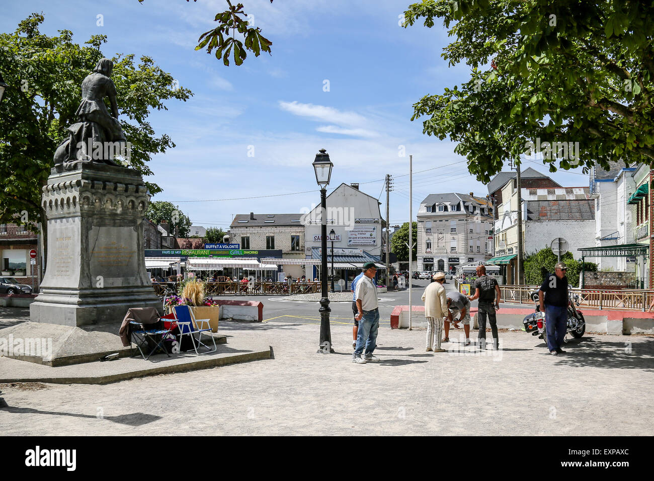 Menschen spielen die typicalFrench Partie Boule im Schatten der Statue von Jeanne d'Arc in Le Crotoy Stockfoto