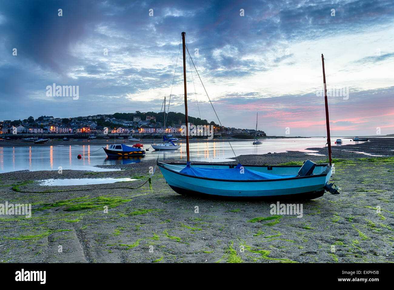 Sonnenuntergang über einem blauen Boot am Strand von Instow, mit Blick auf das hübsche Fischerdorf Dorf Appledore etwas außerhalb von Bideford Stockfoto