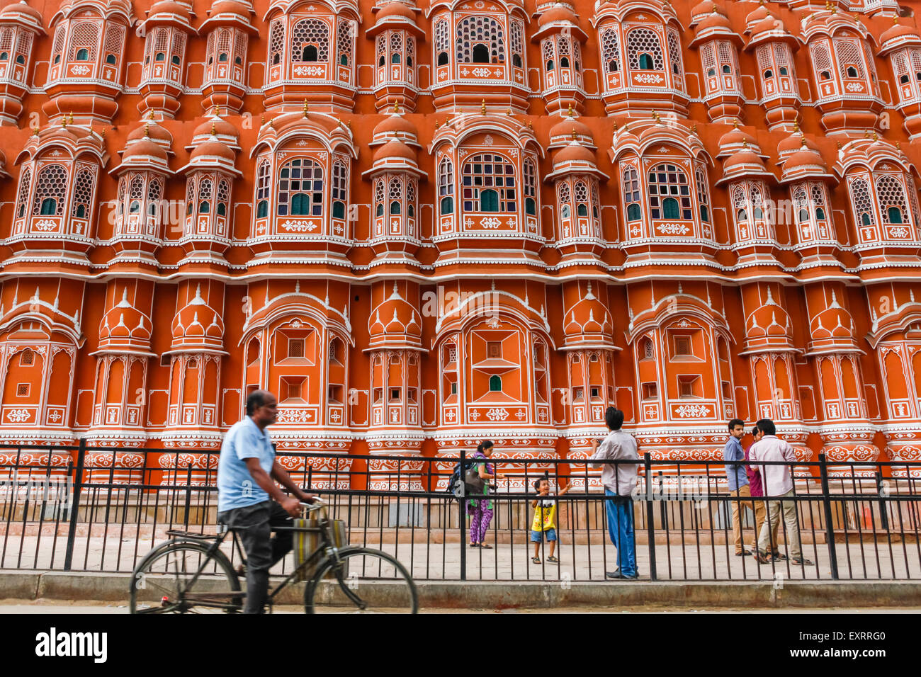 Ein Radfahrer bewegt sich auf der Straße neben einem Fußgängerweg, wo Touristen Freizeit in Hawa Mahal. Jaipur, Rajasthan, Indien. Stockfoto