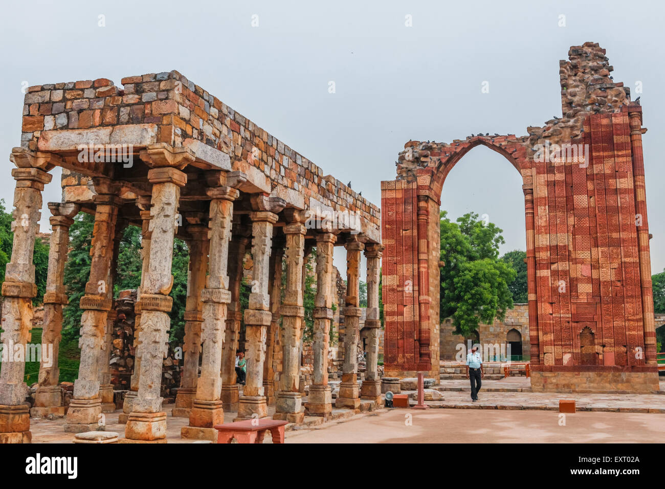 Ein Sicherheitsbeamter, der unter der Quwwat-al-Islam Moschee steht, baut im Qutb Minar Komplex, Mehrauli, Delhi, Indien. Stockfoto