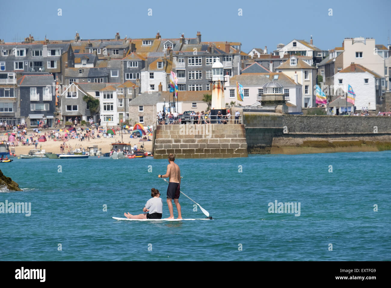 St. Ives, Cornwall, UK: Paar auf Paddleboard mit St Ives im Hintergrund. Stockfoto