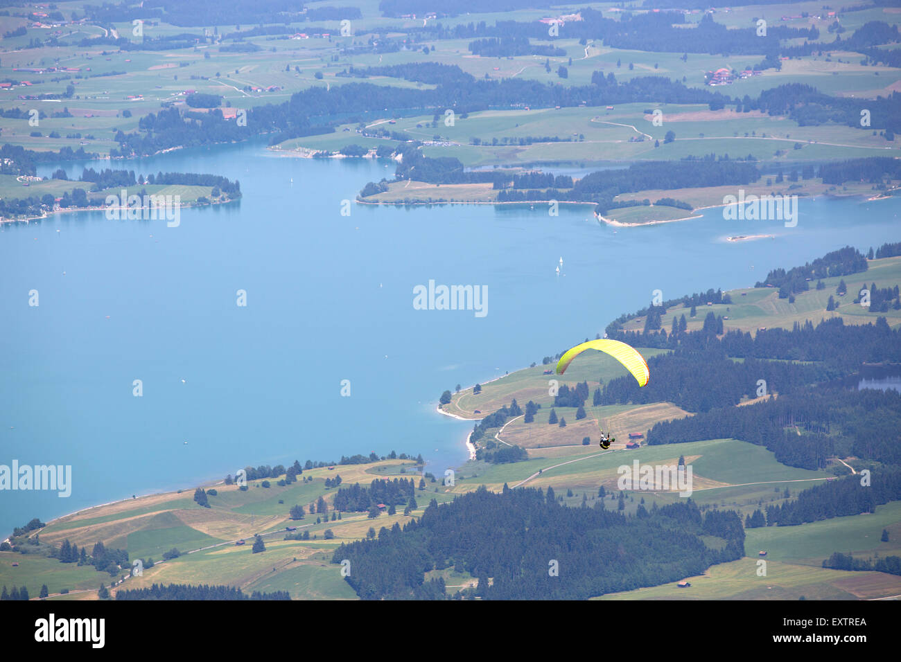 Gleitschirm fliegen über See Forggensee in bayrischen Bergen Stockfoto
