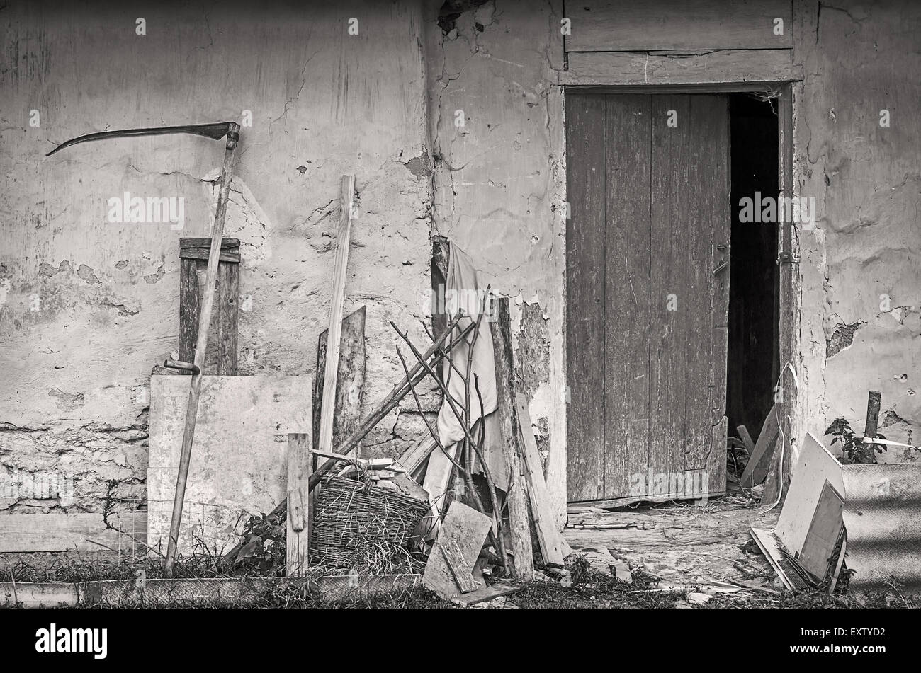 Landwirtschaftliche Geräte in der Nähe von Mauer der alten Schuppen. Schwarz / weiß Foto. Stockfoto