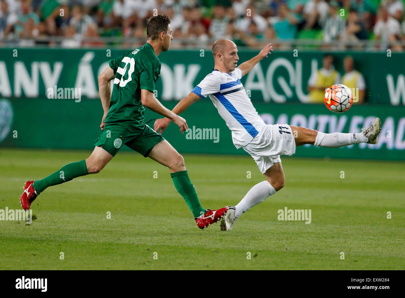 Budapest, Ungarn. 16. Juli 2015. Von Zoltan Gera Ferencvaros (l) Tritte den Ball Weg Jovan Blagojevic von Zeljeznicar während Ferencvaros vs. Zeljeznicar UEFA EL Qualifikation Fußball Spiel in Groupama Arena. Bildnachweis: Laszlo Szirtesi/Alamy Live-Nachrichten Stockfoto