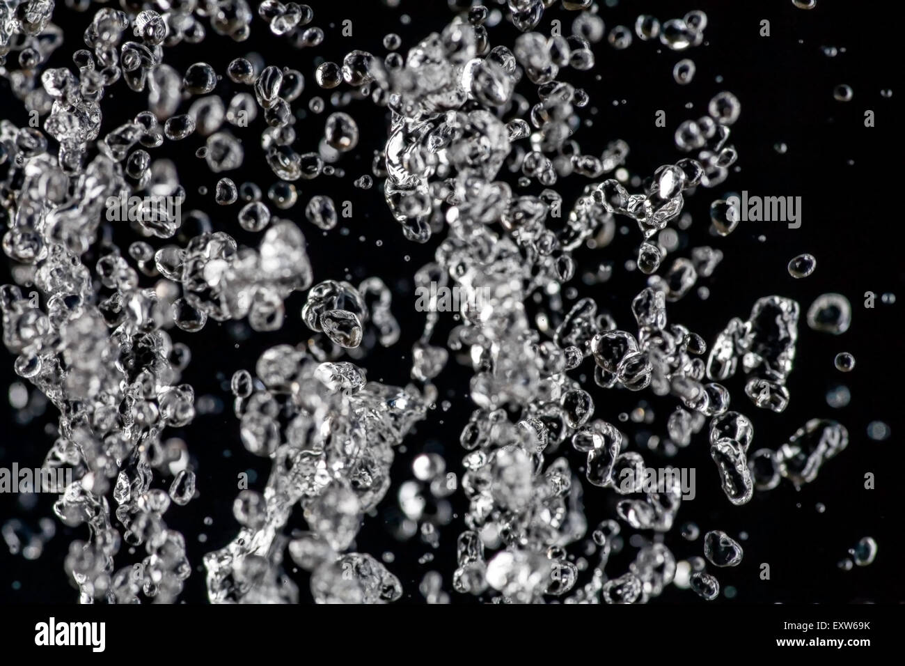 Wassertropfen schweben auf dunklem Hintergrund, Regen oder Wasser Stockfoto