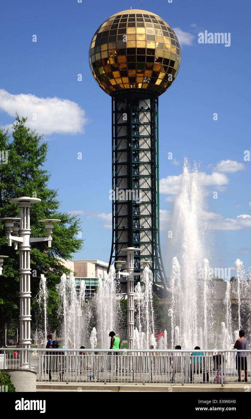 Besucher genießen die Wasserspiele der Weltausstellung Park in der Innenstadt von Knoxville, Tennessee. Die Sunsphere ist im Hintergrund. Stockfoto