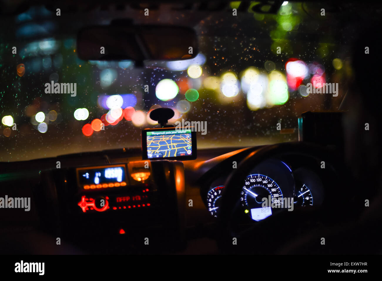 Taxi-Dashboard und Innenräume bei Nachtfahrt in Jakarta, Indonesien. Stockfoto