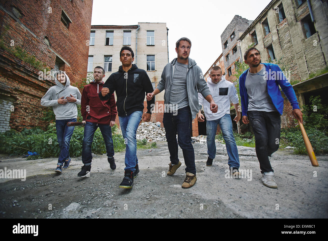 Gruppe von gehässigen Hooligans entlang Grunge Ziegel Häuser Stockfoto