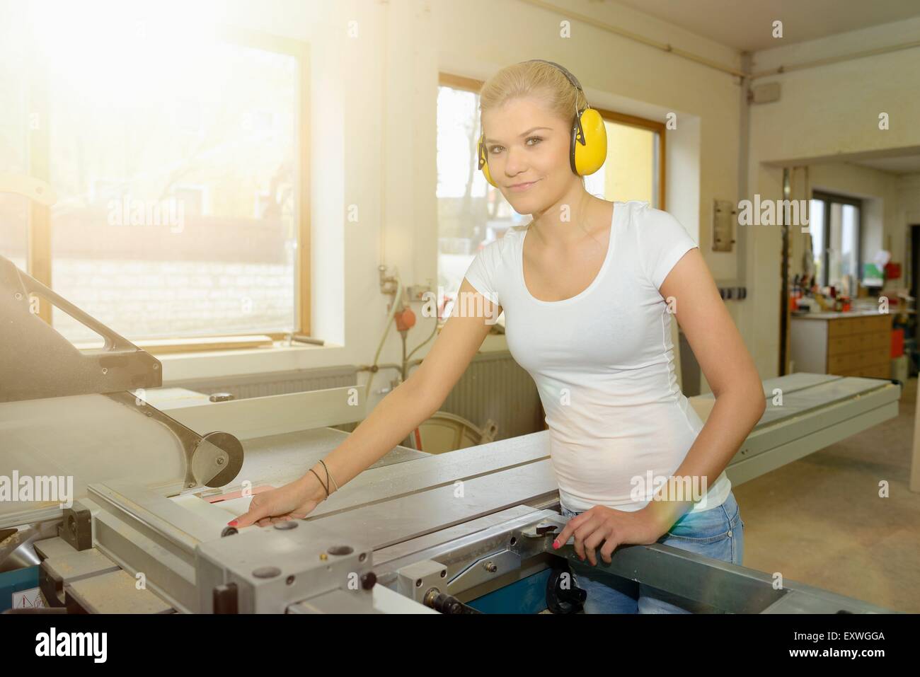 Junge Frau arbeitete in einer Tischlerei auf einer buzzsaw Stockfoto