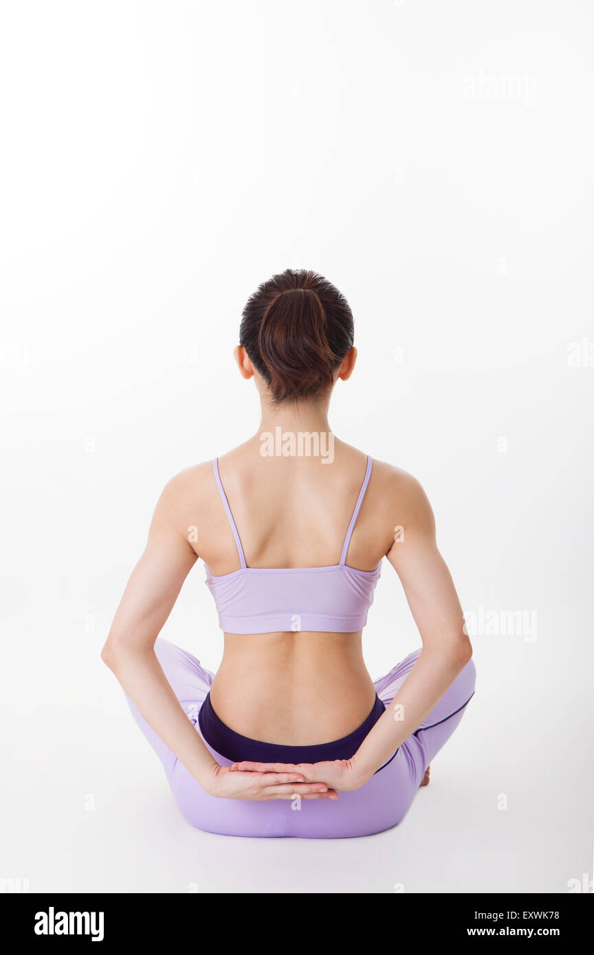 Frau, Yoga zu praktizieren und sitzen mit Sicht nach hinten, Stockfoto