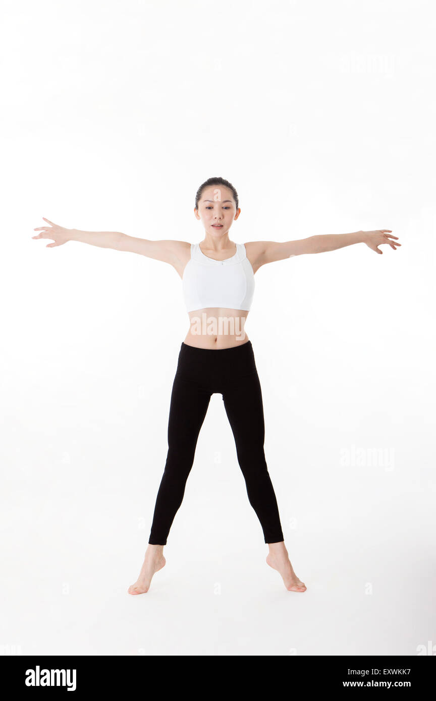 Frau mit ausgestreckten Armen Yoga zu praktizieren, Stockfoto