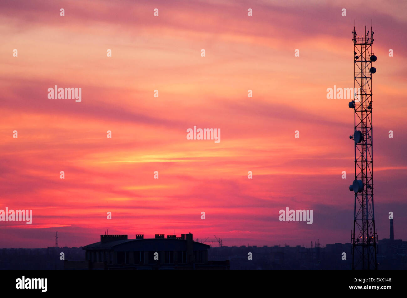 Turm von Mobilfunkantennen auf einem Hintergrund von roten Wolken bei Sonnenuntergang Stockfoto