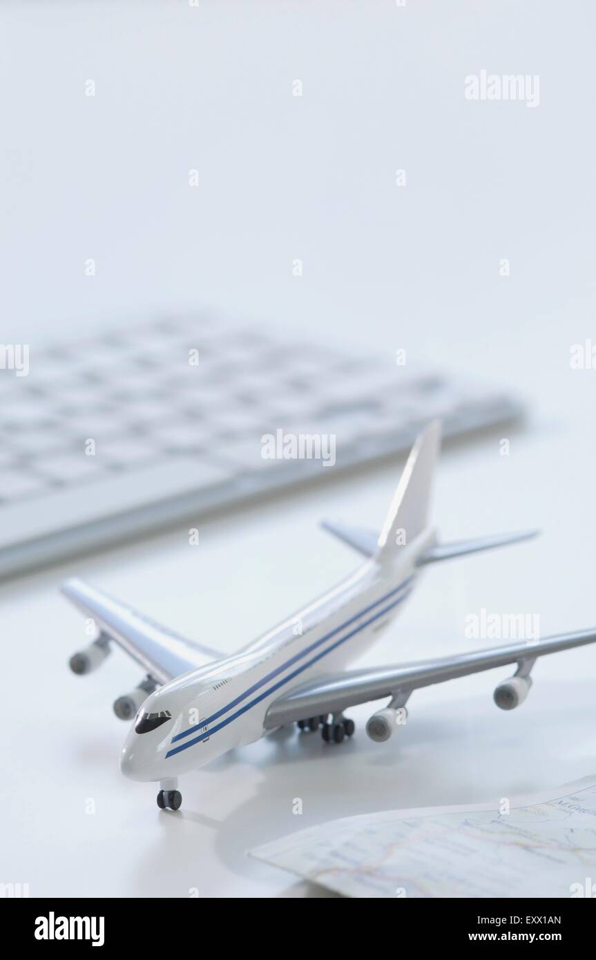 Modellflugzeug, Tastatur und Karte auf Schreibtisch Stockfoto