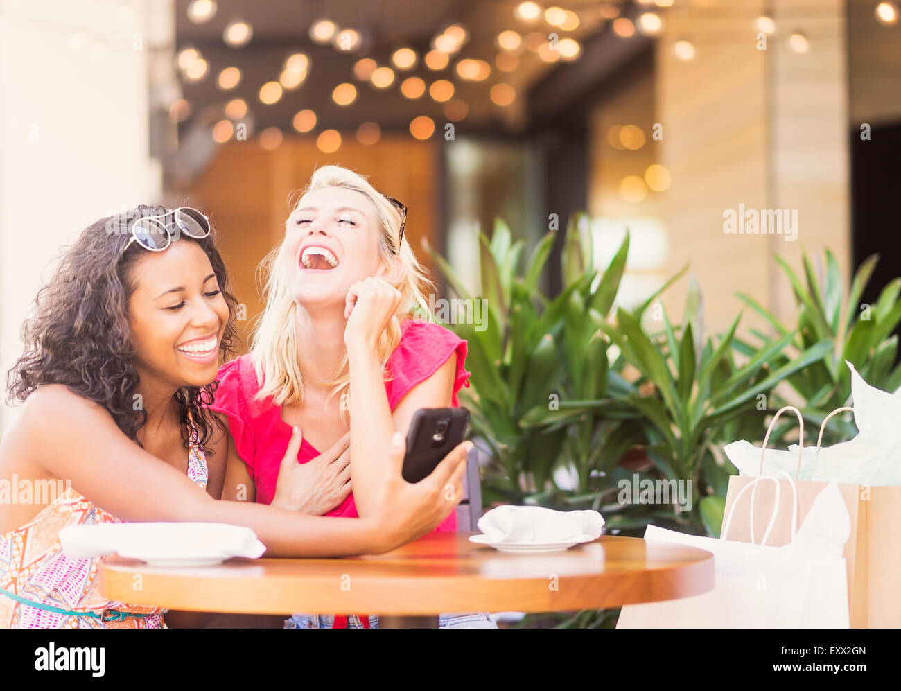 Freundinnen mit Smartphone im café Stockfoto