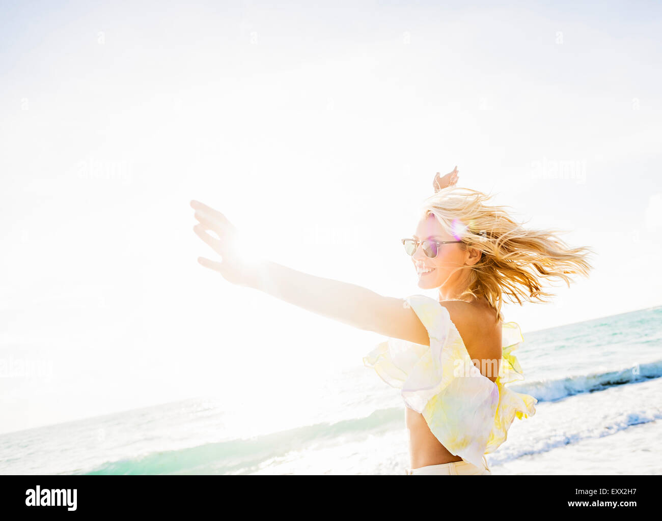 Junge Frau lächelnd am Strand Stockfoto