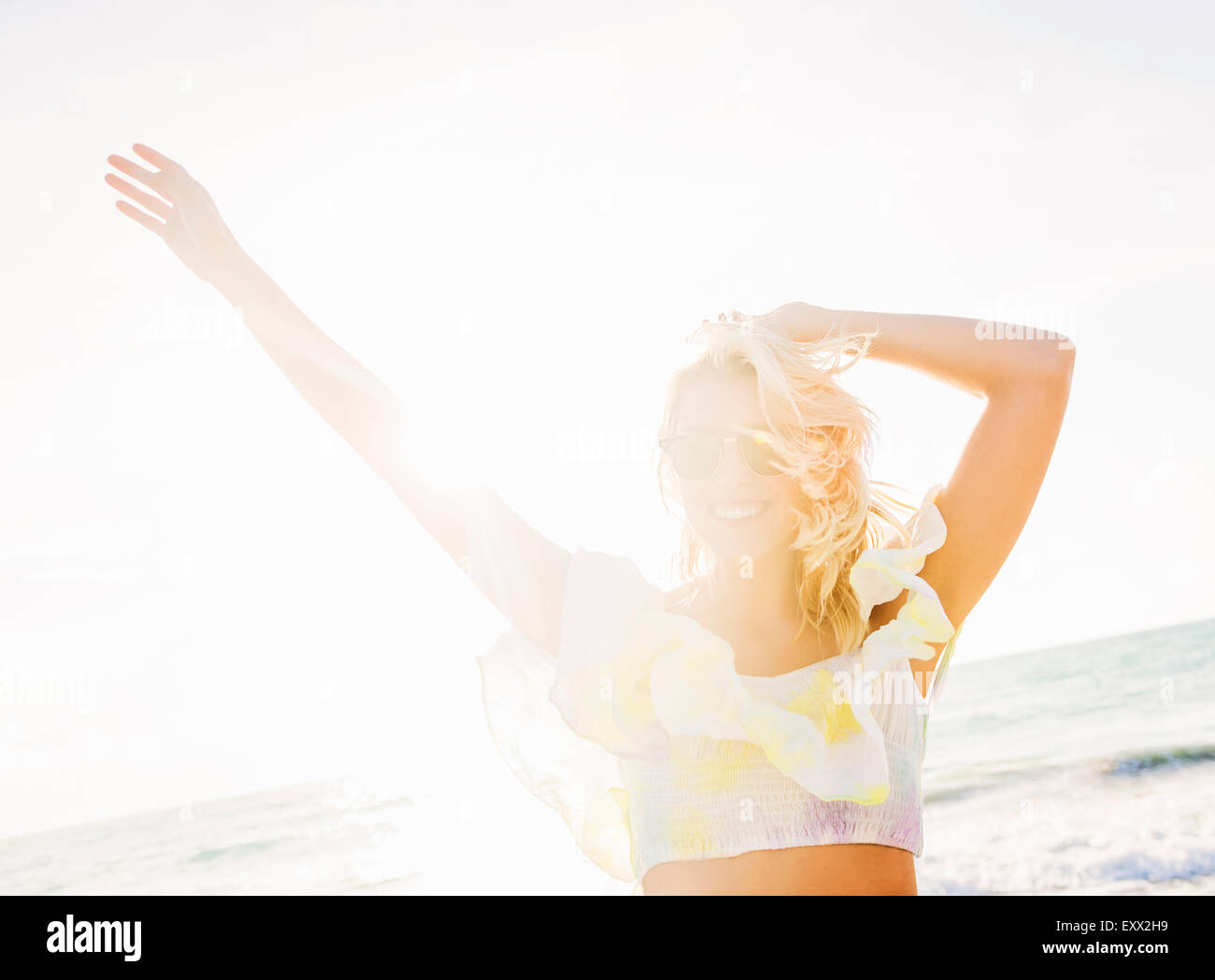 Junge Frau lächelnd am Strand Stockfoto