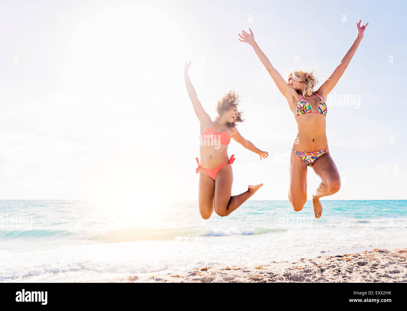 Freundinnen am Strand springen Stockfoto