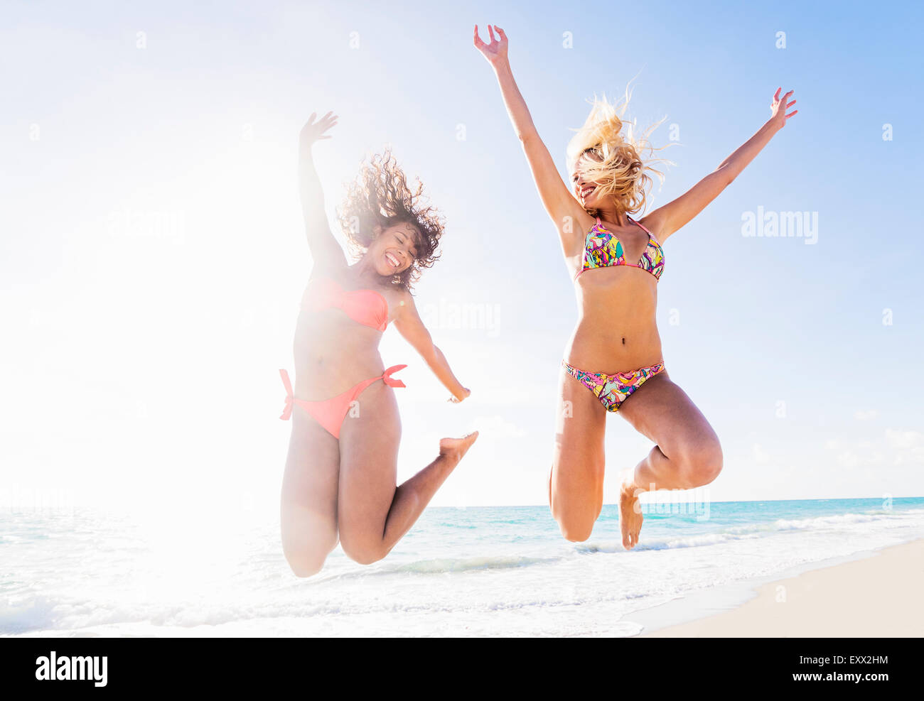 Freundinnen am Strand springen Stockfoto