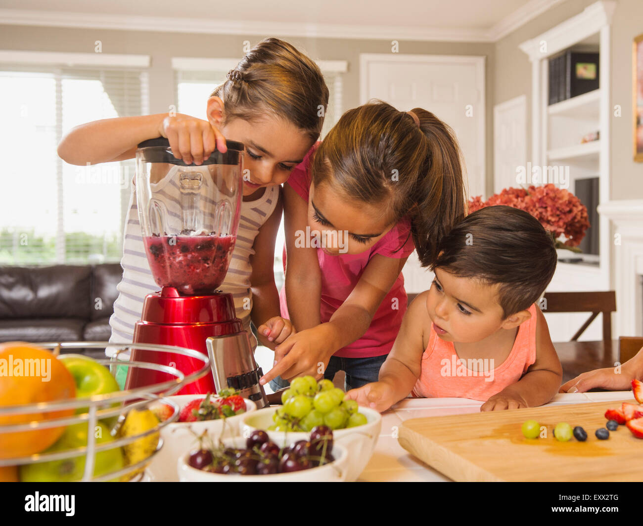 Kinder (2-3, 6-7, 8-9) Vorbereitung Fruchtcocktails Stockfoto