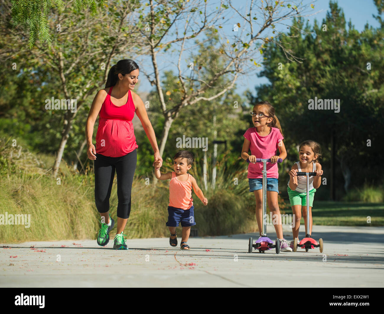 Schwangere Mutter und Kinder (2-3, 6-7, 8-9) walking im freien Stockfoto