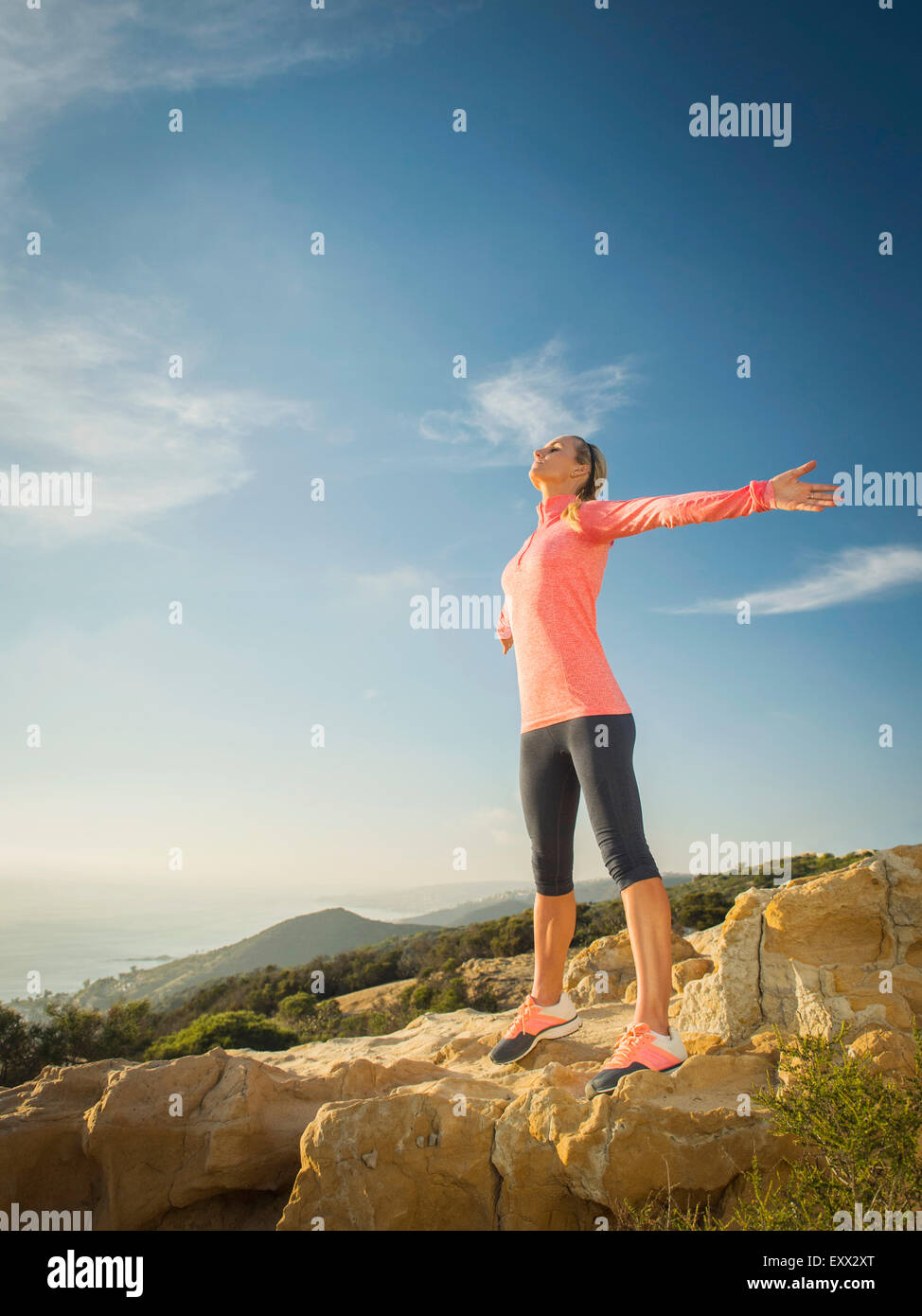 Frau in Sportkleidung mit ausgestreckten Armen Stockfoto