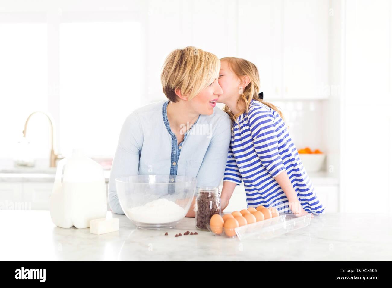 Mädchen (4-5) in Mutters Ohr flüstern Stockfoto
