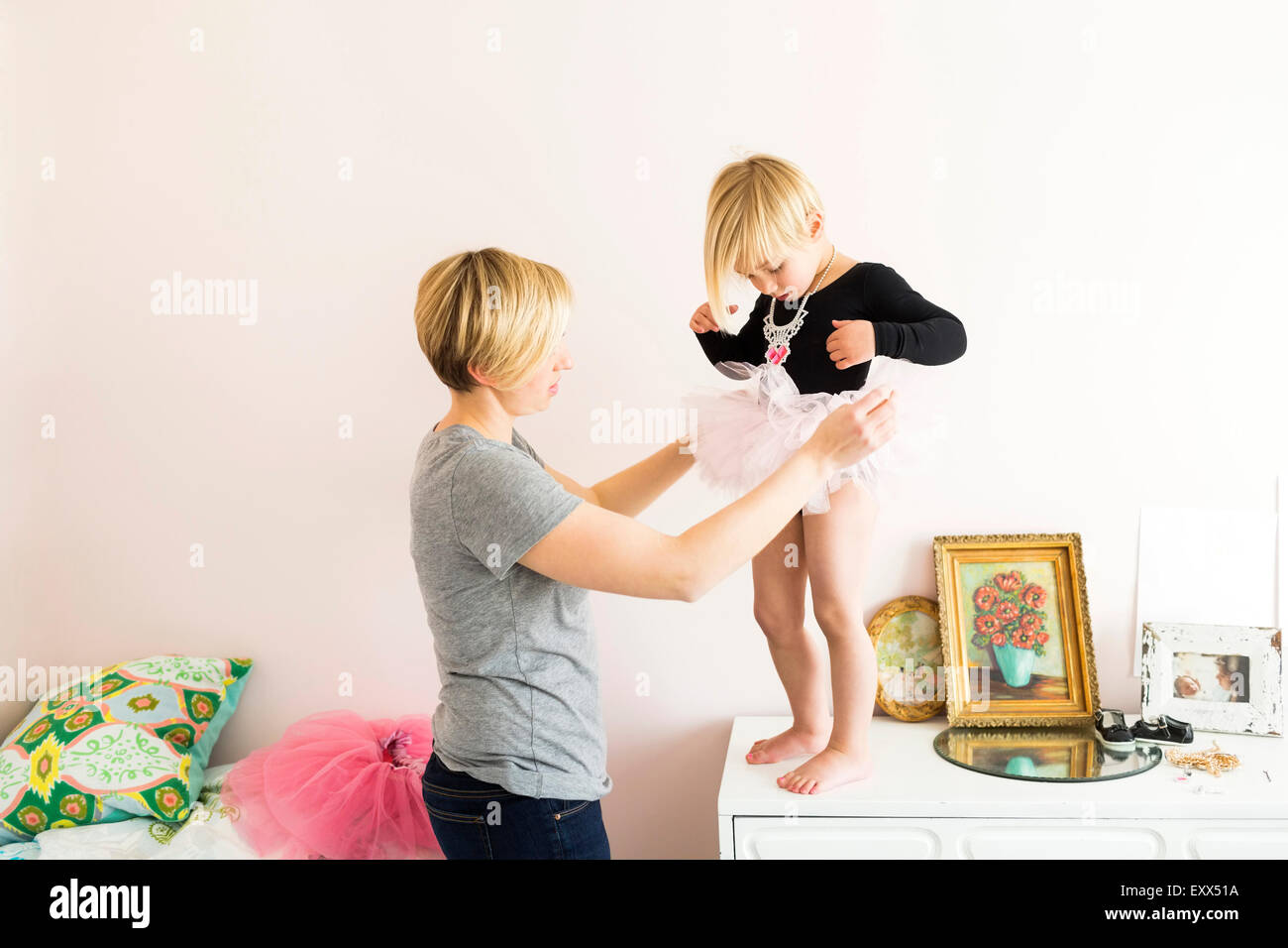 Frau hilft Tochter (4-5) mit Kostüm Stockfoto
