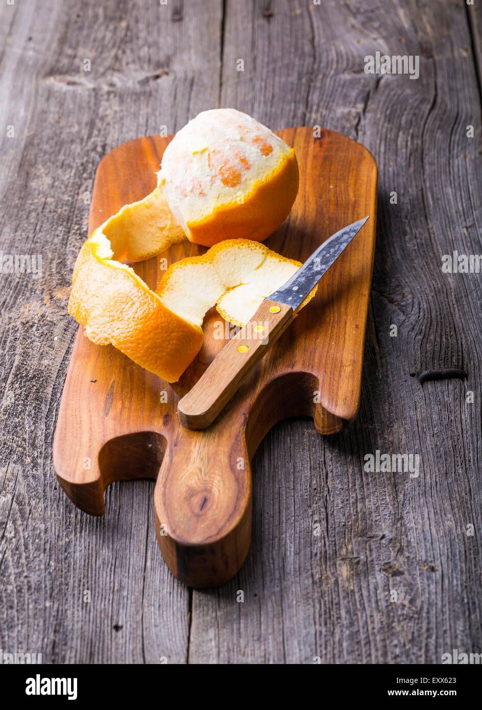 Geschälte Orange auf Holzbrett. Studio mit mystischen Lichteffekt erschossen Stockfoto