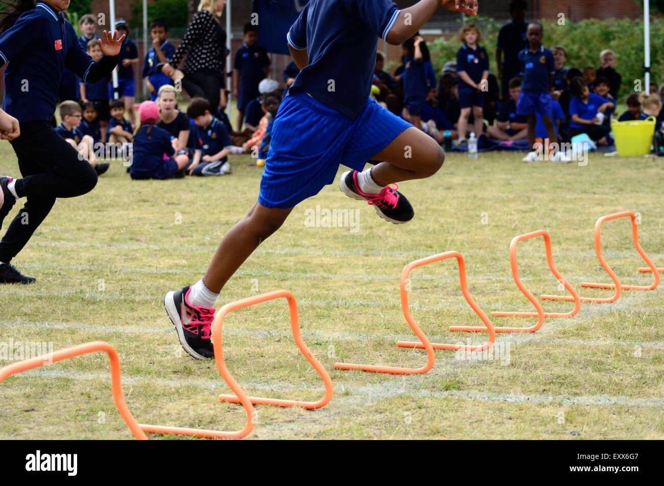 Das Hürden-Rennen an einer Grundschule Sporttag. Stockfoto
