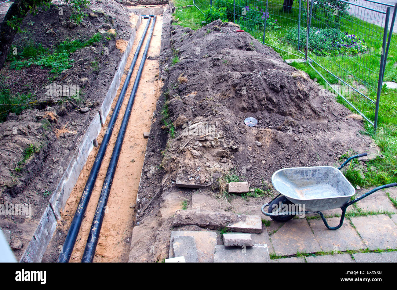 moderne Kunststofftechnik schwarz Heizungsrohre im Graben und gebrauchte barrow Stockfoto