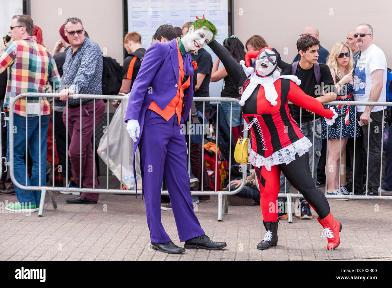 London, UK. 17. Juli 2015. Ventilatoren, einschließlich dieser beiden Menschen gekleidet, der Joker und Harley Quin von Batman, versammeln sich vor Olympia in Kensington für den Eröffnungstag der London Film & Comic Con, eine Konvention für Liebhaber von Film, Fernsehen und Comics. Viele Teilnehmer haben die Möglichkeit, ihre auf Bildschirm-Helden während der dreitägigen Veranstaltung durch live-Auftritte von Hollywood Filmstars zu treffen. Bildnachweis: Stephen Chung/Alamy Live-Nachrichten Stockfoto