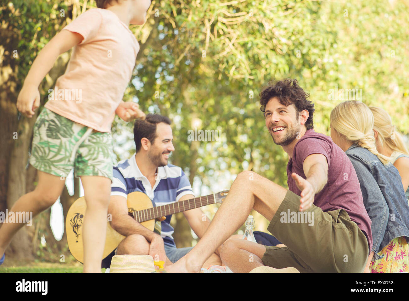 Mann beim Picknick beobachten Kinder spielen Stockfoto