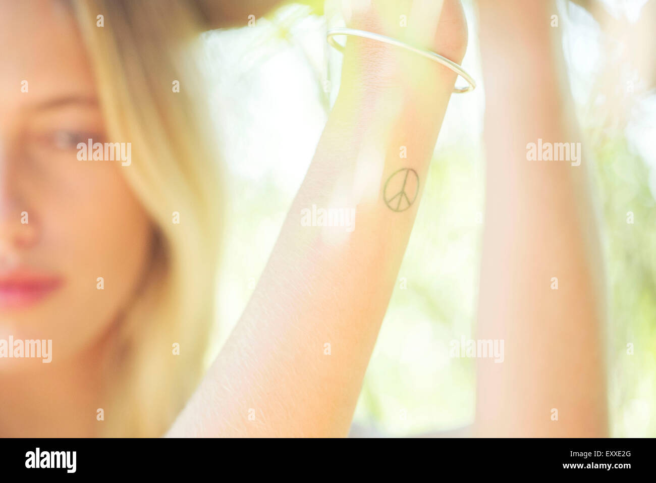 Frau mit Peace-Zeichen tattoo Stockfoto