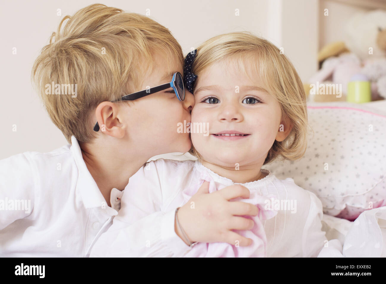 Junge küssen Schwester Wange Stockfoto