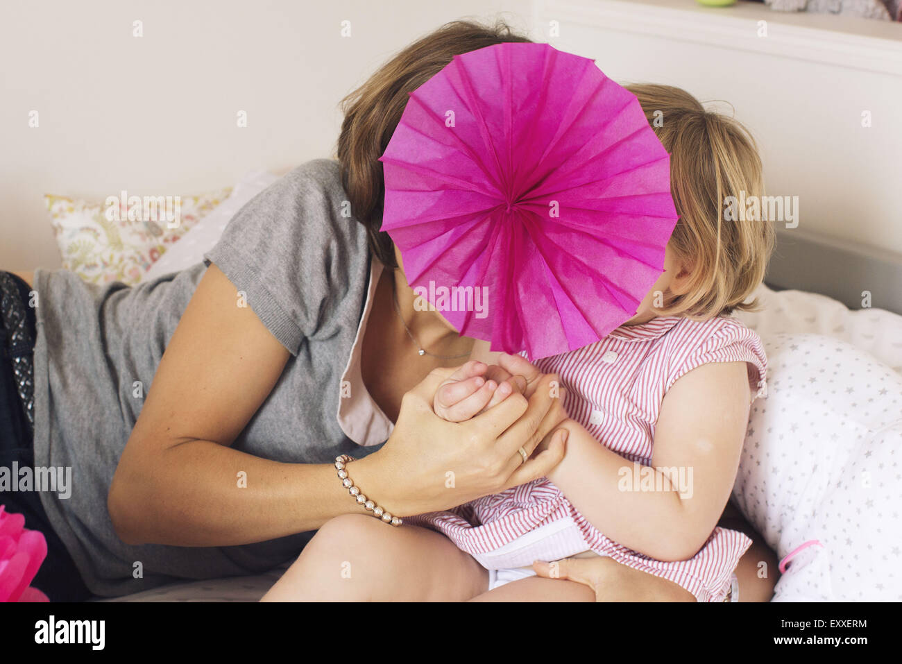 Mutter und Tochter versteckt sich hinter Tissue-Papierblume Stockfoto