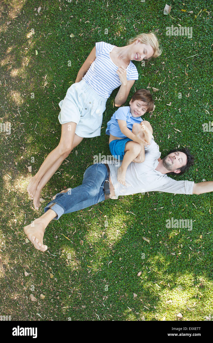 Junge Familie mit jungen liegen zusammen auf dem Rasen Stockfoto