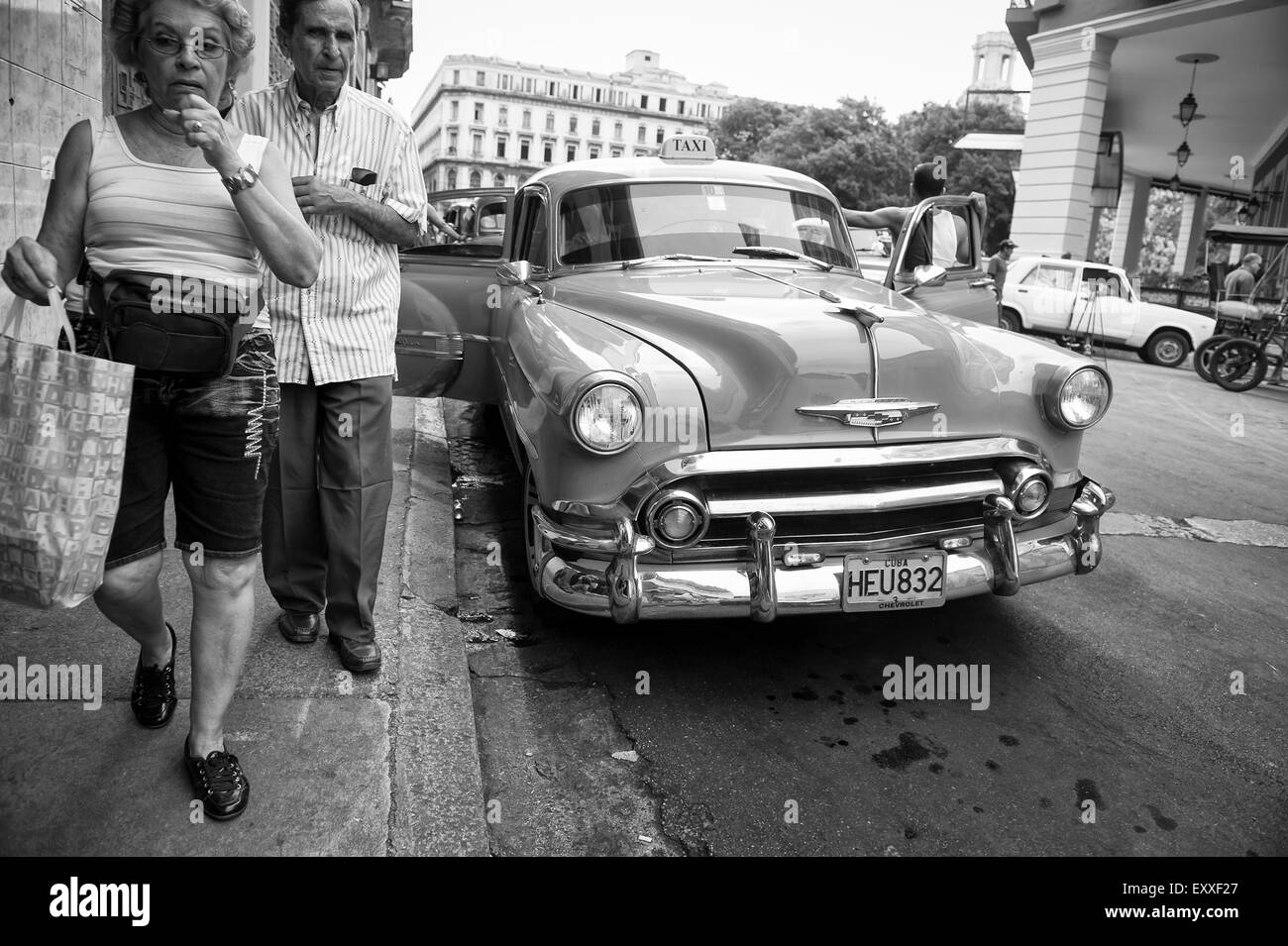 Havanna, Kuba - 13. Juni 2011: Kubanische Fußgänger passieren einen amerikanischen Oldtimer auf einer Straße im Centro. Stockfoto