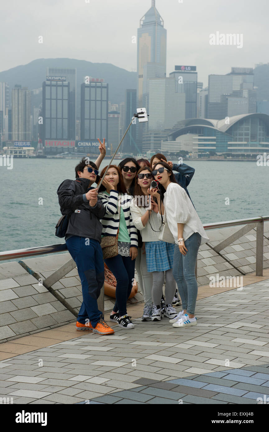 Gruppe von Frauen, die unter einem Selfie auf Tsim Sha Tsui Promenade, Hong Kong, China. Stockfoto