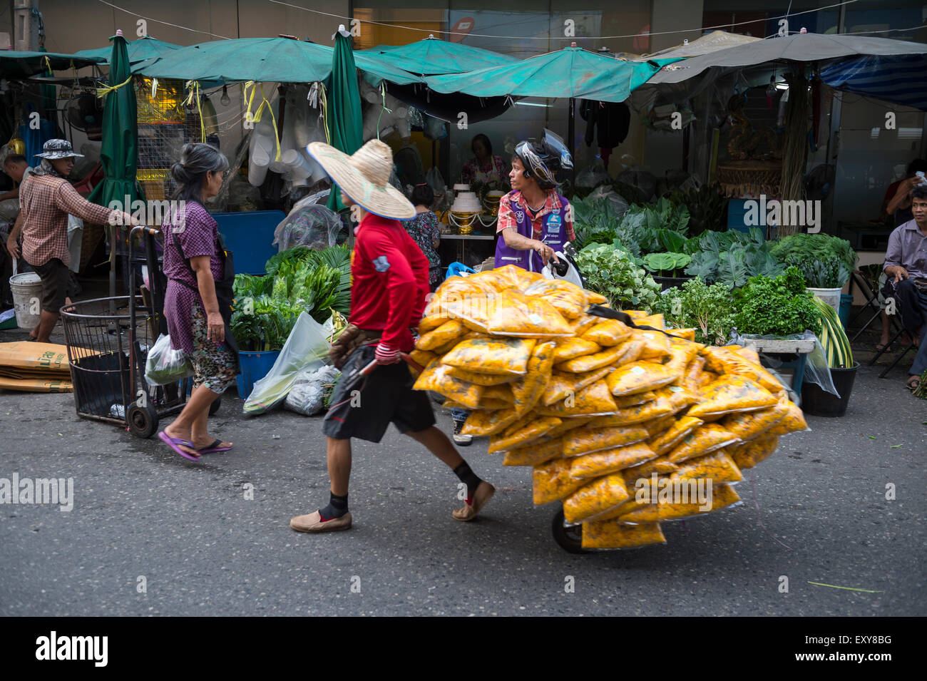 BANGKOK, THAILAND - 27. Oktober 2014: Arbeiter zieht Karren mit gelben Blumen entlang der Straßen von den anstrengenden Outdoor-Markt. Stockfoto
