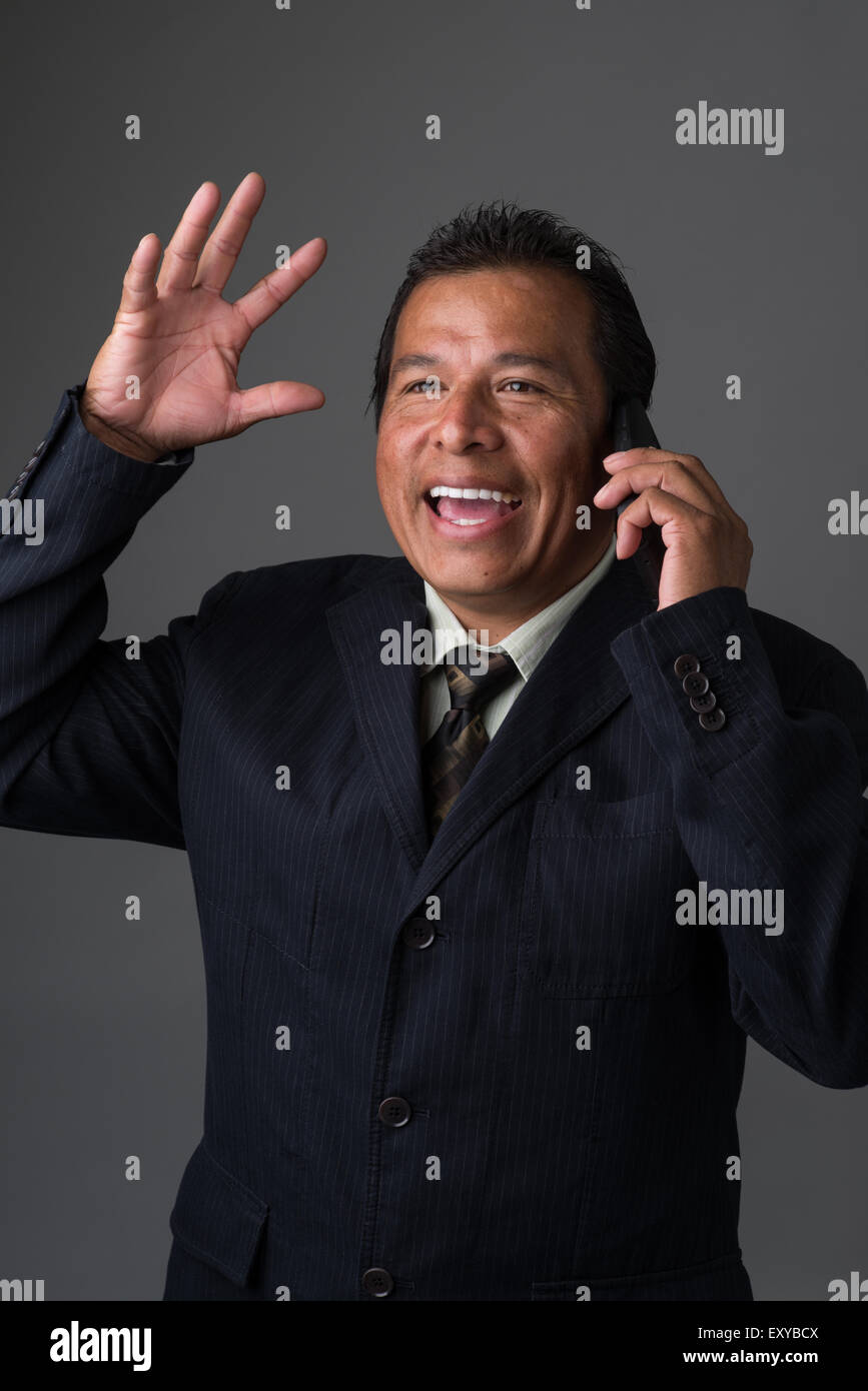 Hispanic Geschäftsmann reden auf seinem Handy, Lächeln und lachen, seine Hand winken Stockfoto
