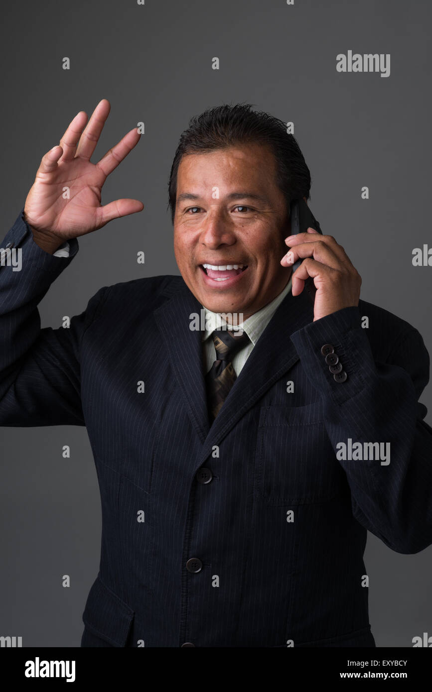 Hispanic Geschäftsmann reden auf seinem Handy, Lächeln und lachen, seine Hand winken Stockfoto